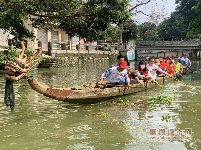 欧阳效照带领志愿者们乘坐龙舟开展河涌垃圾清理活动。.jpg