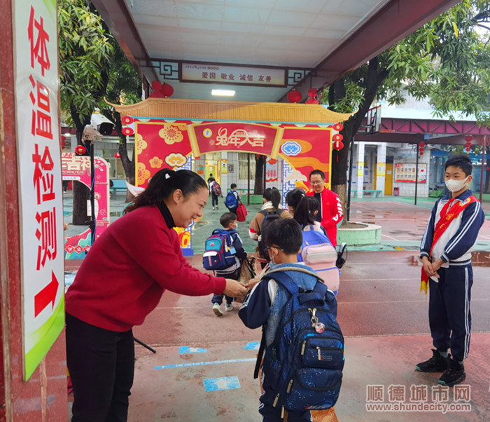 圖為東風小學全體行政在校門口為學生派發兔年愿望卡_副本.jpg