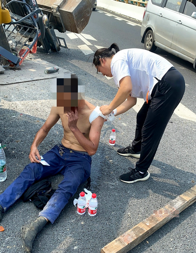 吳廷娟正在為貨車司機處理傷口。.png