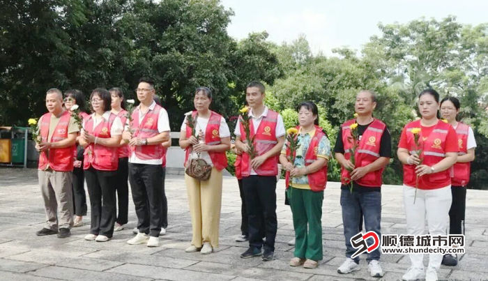 9月3日,三十余位志愿者与社区群众手持金黄菊花,肃立于西海抗日烈士陵园抗日烈士纪念碑前。.jpg