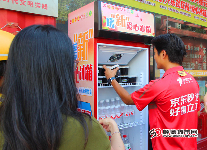 快递员从“爱心冰箱”里取出消暑饮品。.jpg