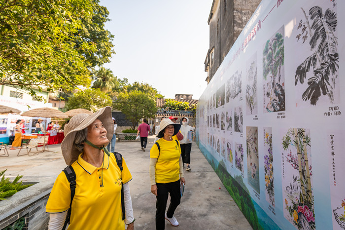 10月9日，“佛山银发力量助力‘百千万工程’志愿服务行动暨古朗村尊老敬贤活动”在古朗村举行，市民正在观看福泽佛老·摄影书画展。顺德融媒记者周焯杰摄2_副本.jpg